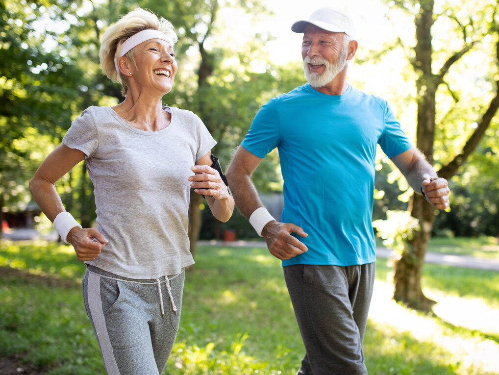 Ein älteres Ehepaar beim Walking im Park.