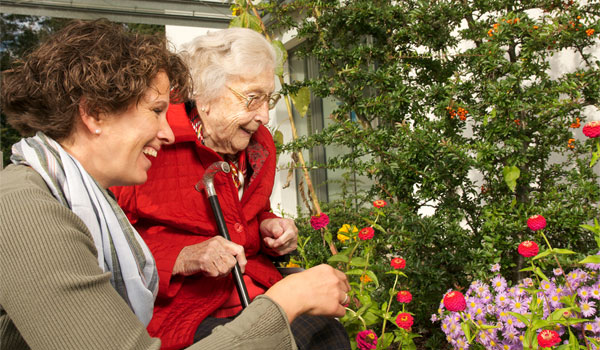 Seniorin im Rollstuhl mit Alltagsassistentin