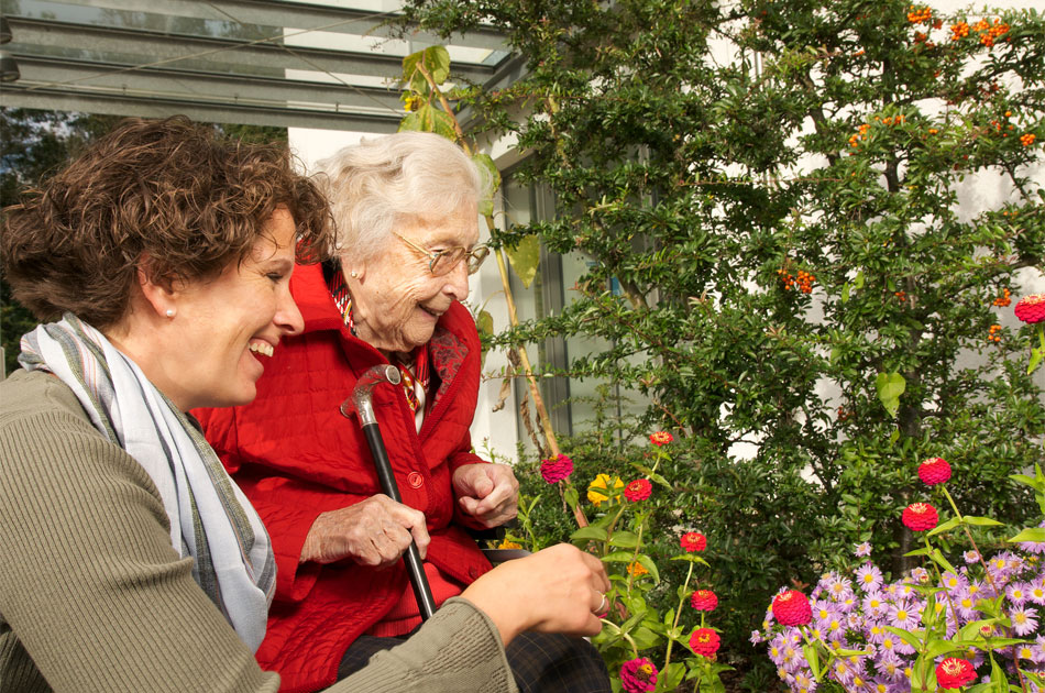 Seniorin im Rollstuhl mit Alltagsassistentin