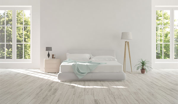 Minimalistisches Bett in einem hellen Raum.