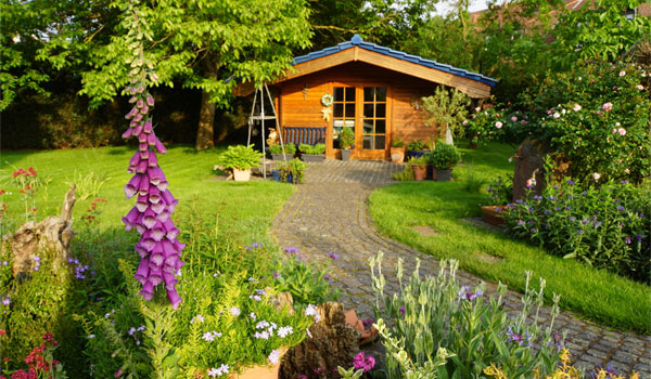 Gartenhaus aus Holz mit breitem Weg