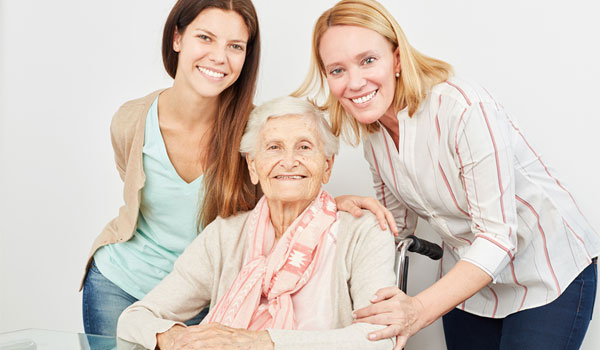 Glückliche Familie. Oma im Rollstuhl, Enkelin und Tochter.