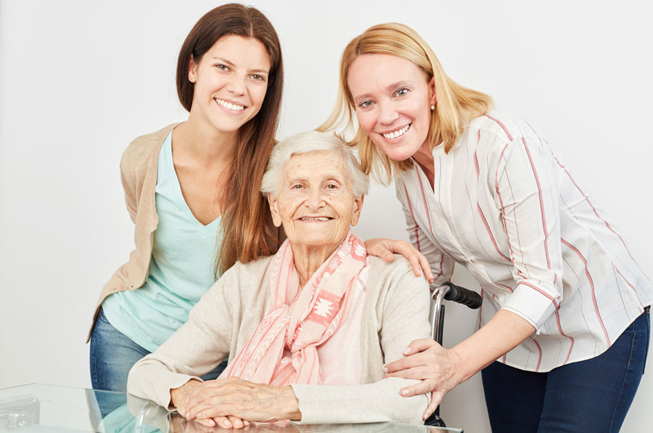 Glückliche Familie. Oma im Rollstuhl, Enkelin und Tochter.