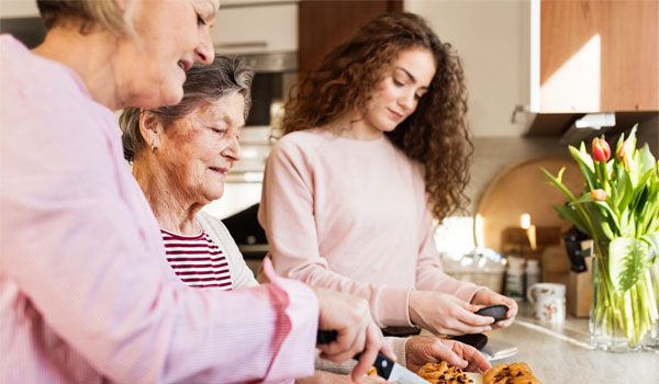 Mutter und Enkelin helfen ihrer Oma in der Küche