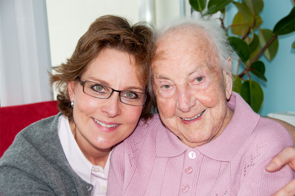 Die Tochter umarmt ihre alte Mutter.