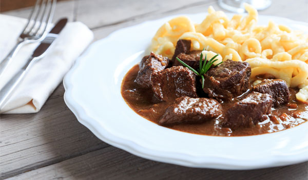 Ein Teller Gulasch mit Nudeln.