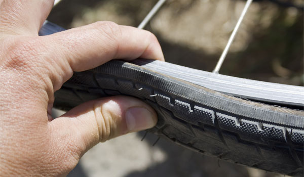 Eine Hand kontrolliert den Fahrradschlauch.