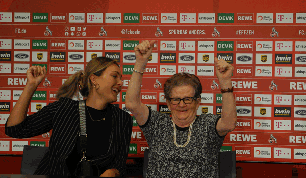 Zwei Teilnehmer, der FC-Stadionführung, auf dem Podium des Pressebereichs sitzend.