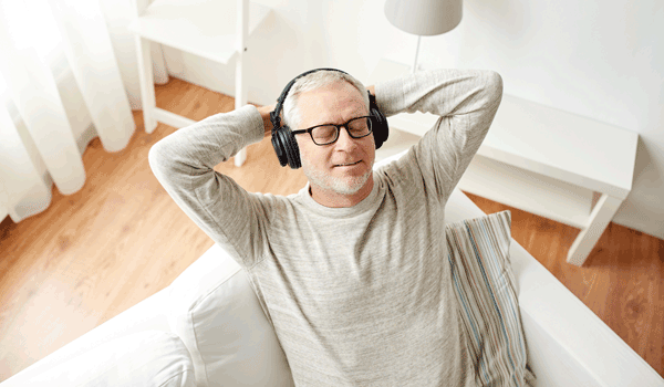 Ein Mann liegt auf der Couch und chillt bei Musik.