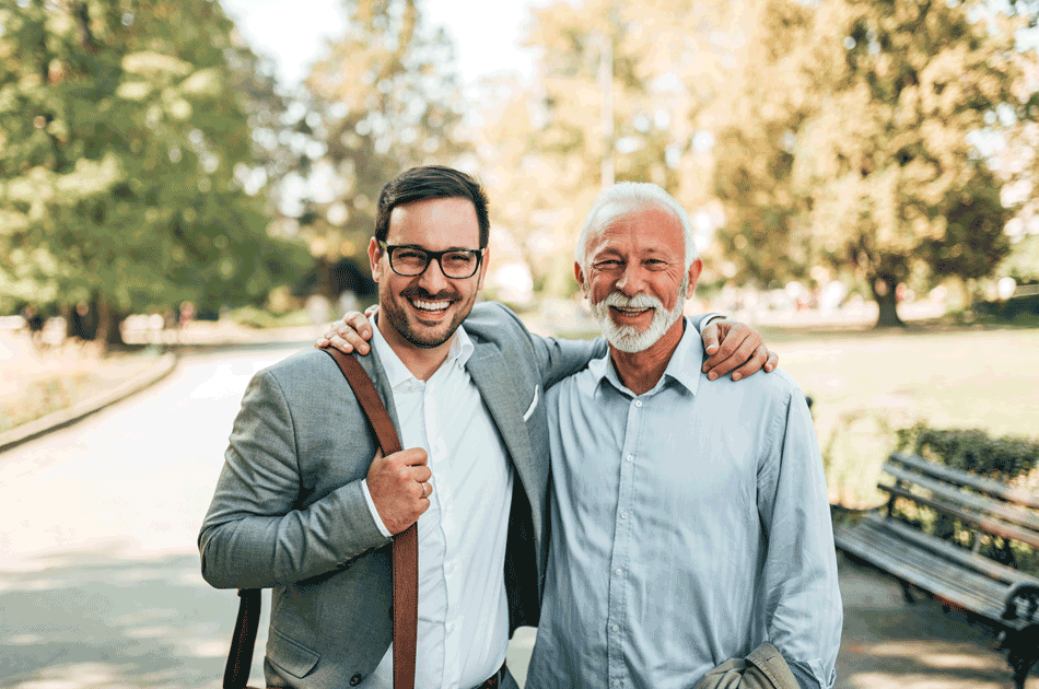 Ein Sohn umarmt seinen Vater im Park.