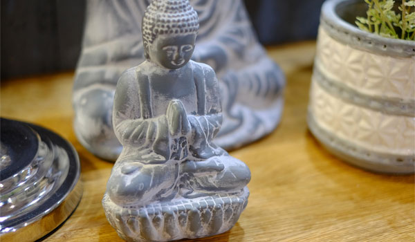 Eine kleine Buddha Statue auf einem Fensterbrett