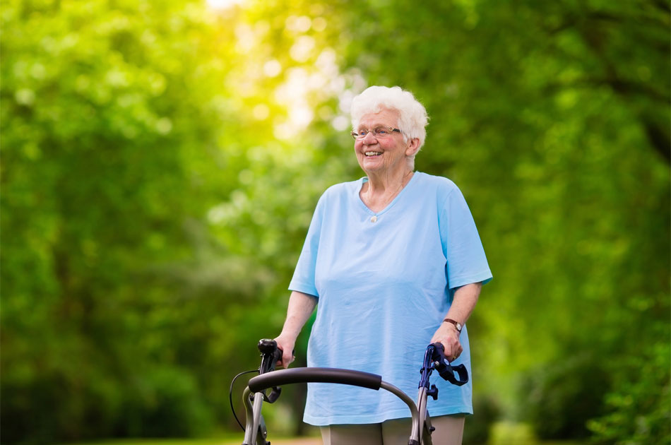 Rentnerin glücklich unterwegs mit ihrem Rollator.