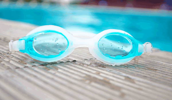 Eine Schwimmbrille liegt am Pool.