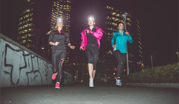 Drei Frauen beim Joggen im Dunkeln.