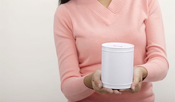 Eine Frau sammelt mit einer Spendendose nach Spenden.