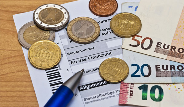 Steuererklärung zusammen mit Geld auf einem Tisch liegend.