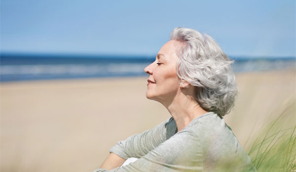 attraktive, grauhaarige Frau genießt das Meer