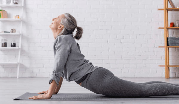 Eine Frau macht die Yoga Übung Kobra bei sich zu Hause.