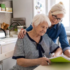 Mutter und Tochter sind in der Küche und beantragen eine Erhöhung des Pflegegrades.