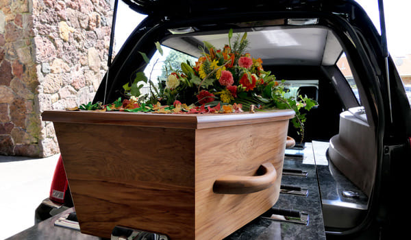 Ein Sarg auf einem Bestattungsauto.