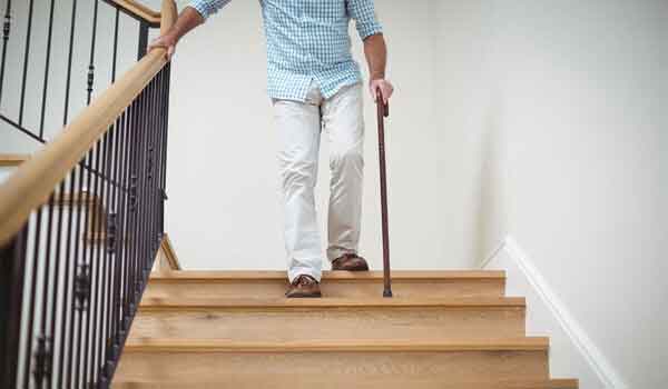 Ein Senior möchte die Treppe hinuntergehen.