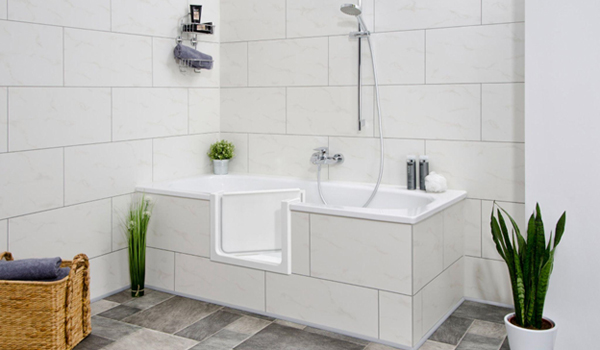 Eine Bad mit einer Badewanne, die mit Hilfe einer Badewannentür bestiegen werden kann.
