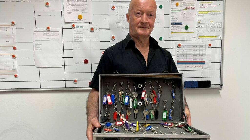 Hanno Heidrich von unserem Hausnotrufservice hält einen Koffer mit Schlüsseln in der Hand.