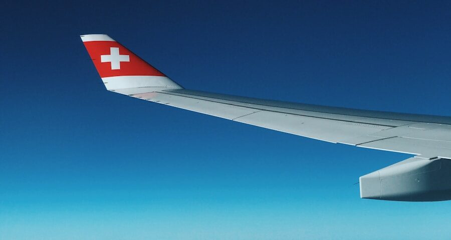Flugzeugflügel mit Schweizer Kreuz auf dem Winglet vor blauem Himmel