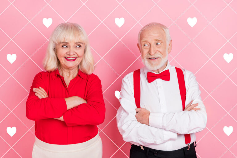 Ein verliebtes älteres Paar vor einem rosa Hintergrund mit Herzen.