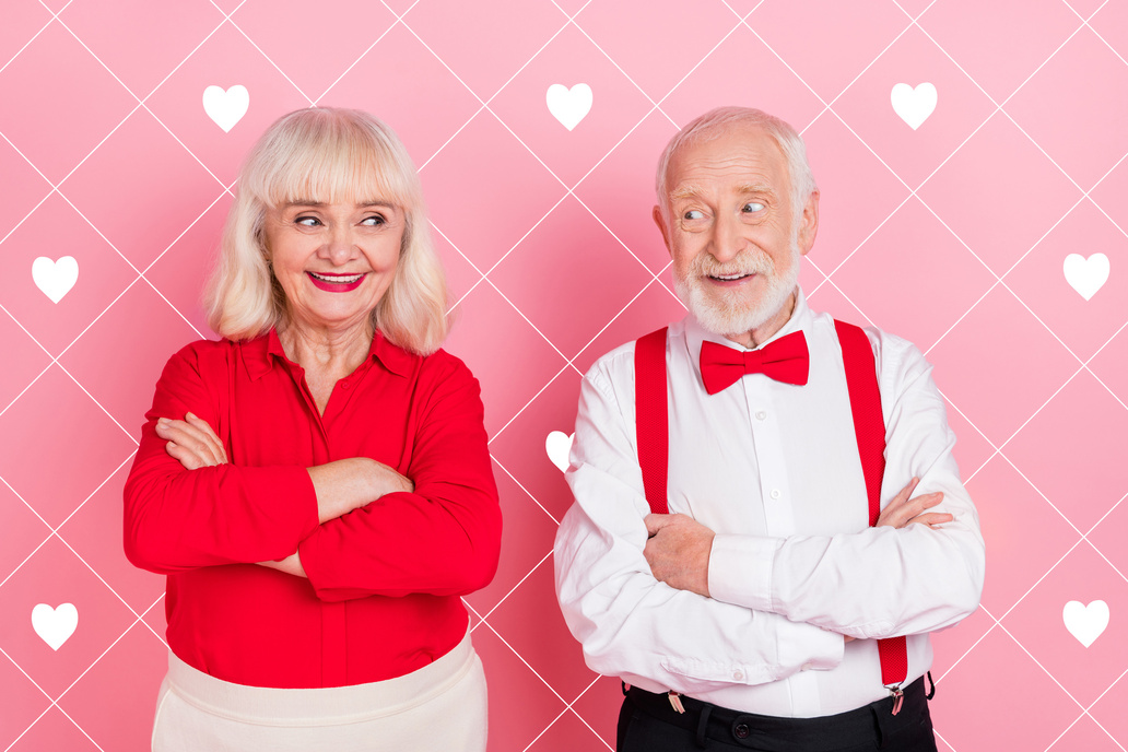 Ein verliebtes älteres Paar vor einem rosa Hintergrund mit Herzen.